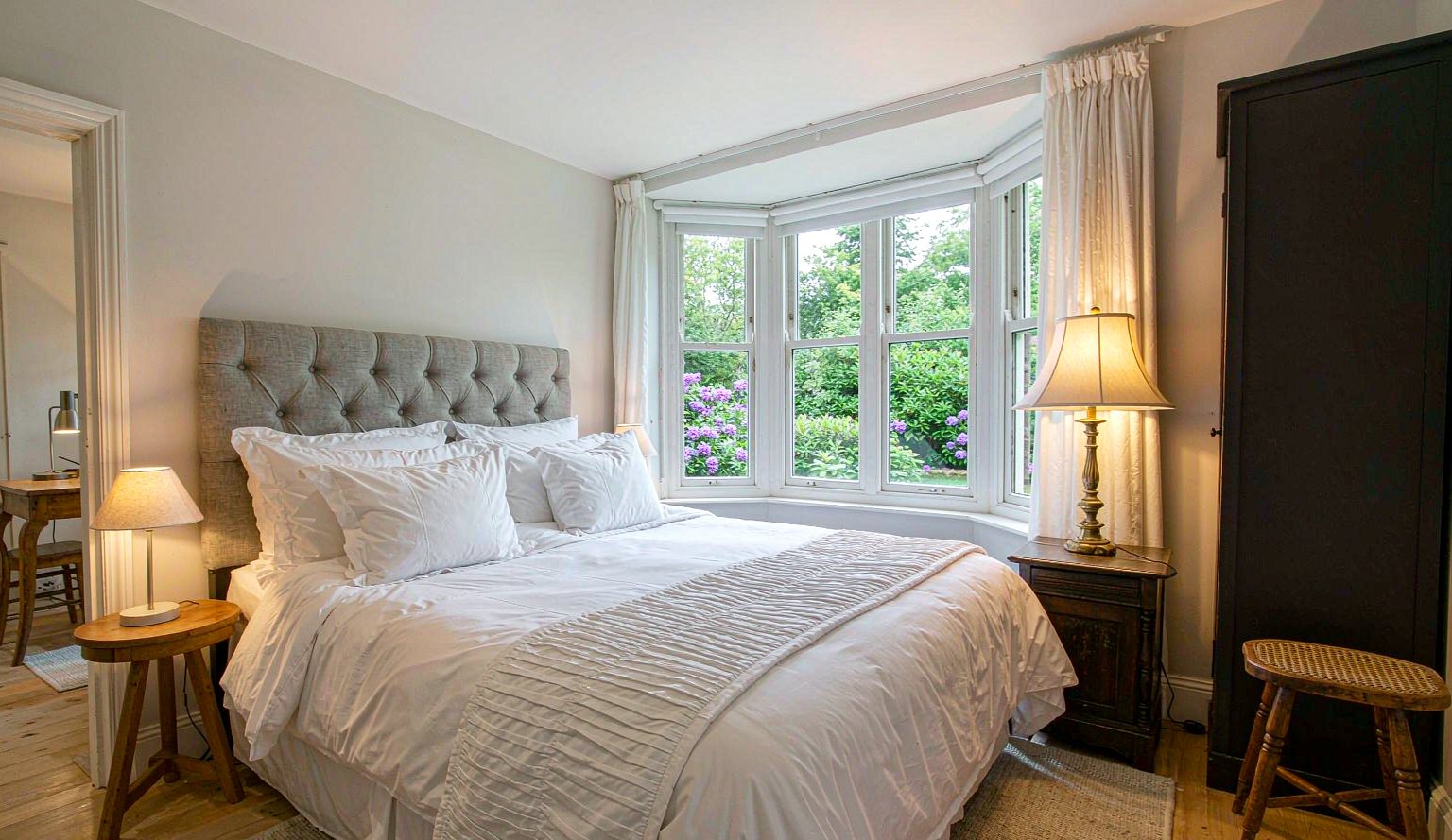 Home Double bedroom with white linen and bay window