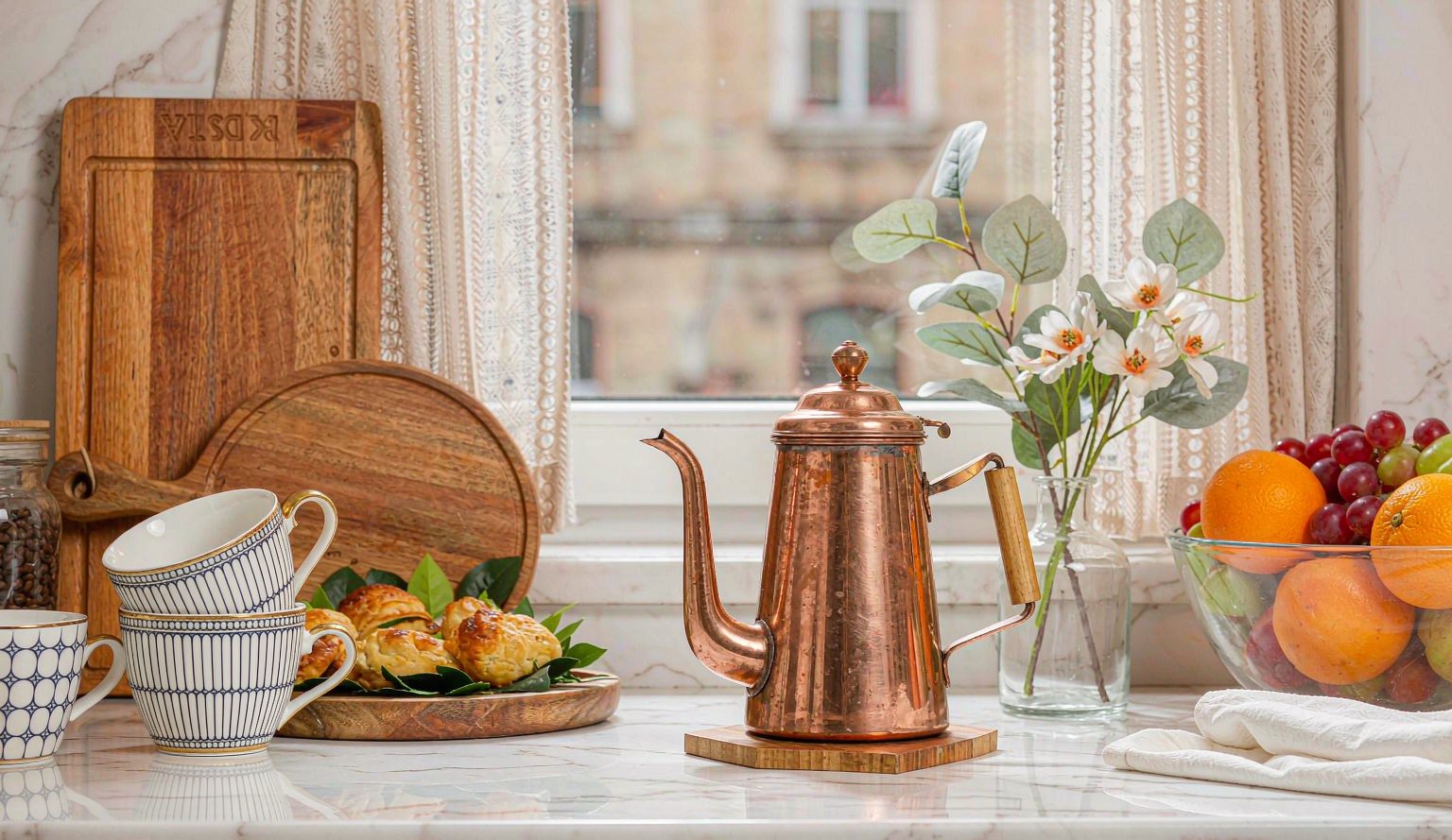 Home Styled kitchen counter with coffee pot, mugs and fresh fruit